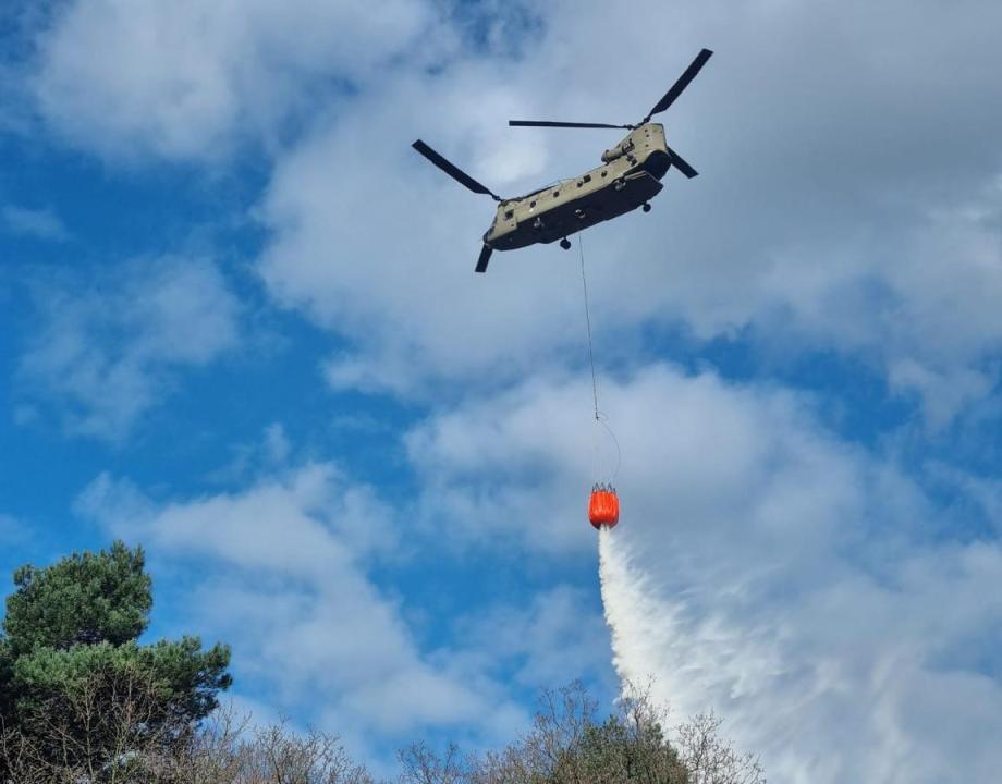 Blushelicopter defensie met oranje waterzak