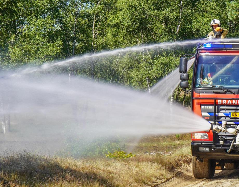 Brandweerauto tijdens het blussen van een natuurbrand